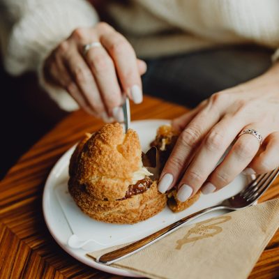kaboompics_a-woman-drinks-coffee-and-eats-a-dessert-in-a-caf-10366